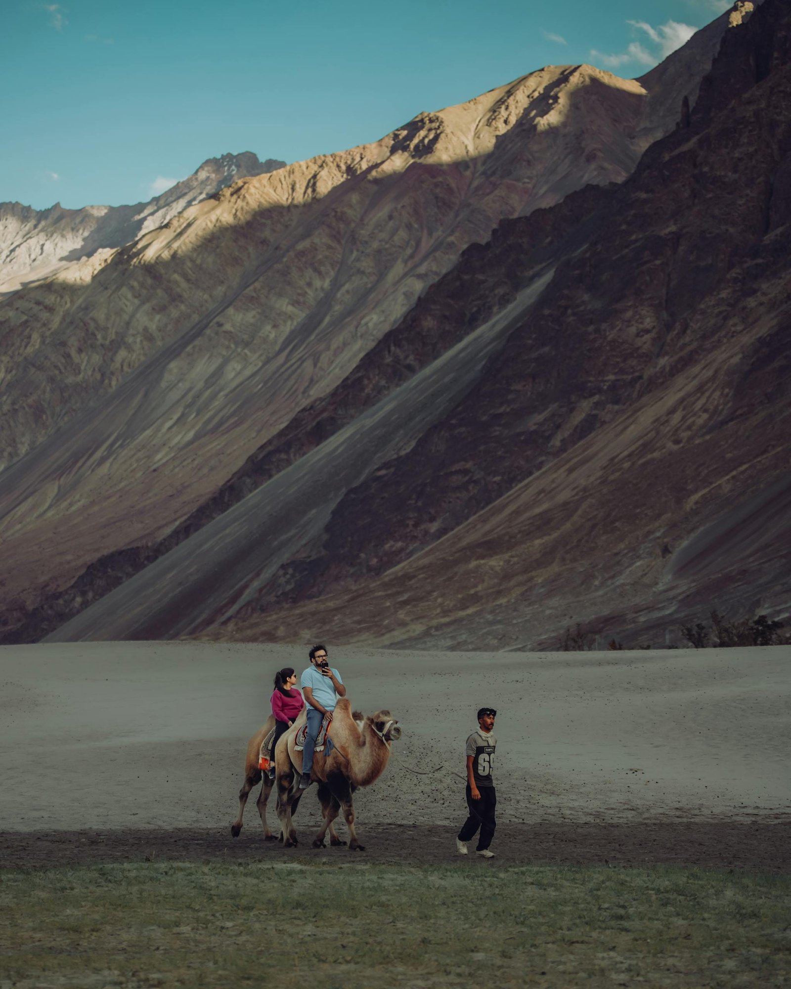 A couple enjoying a camel ride in the stunning landscapes of Nubra Valley, Ladakh, India.