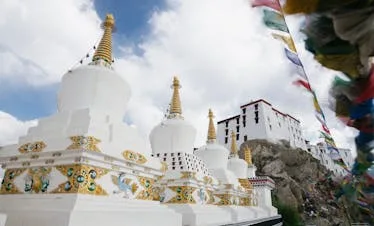 Beautiful view of Thiksey Monastery with white stupas under a bright sky in Ladakh, India.