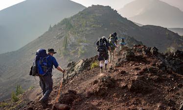 Group of hikers trekking on a rugged mountain trail in Oregon's scenic outdoors.
