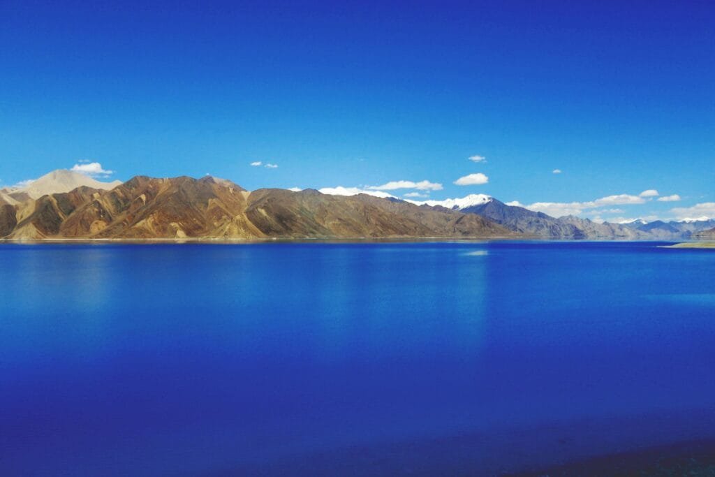 pexels-photo-688576-688576 Idyllic view of Pangong Lake with mountains under a clear blue sky, showcasing nature's tranquility.