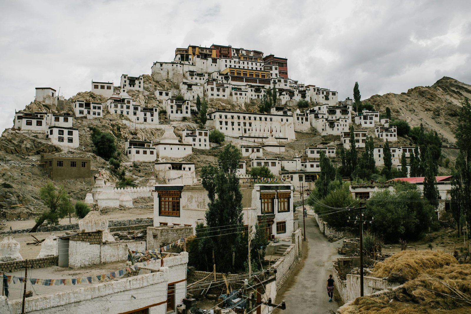 Scenic view of Thiksey Monastery nestled in the mountains of Ladakh, India with overcast skies.