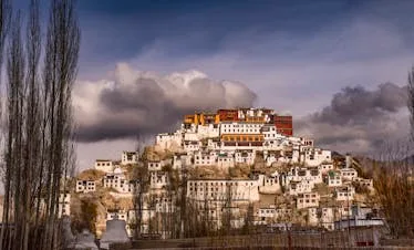 Stunning view of Thiksey Monastery under dramatic clouds in Leh, India.