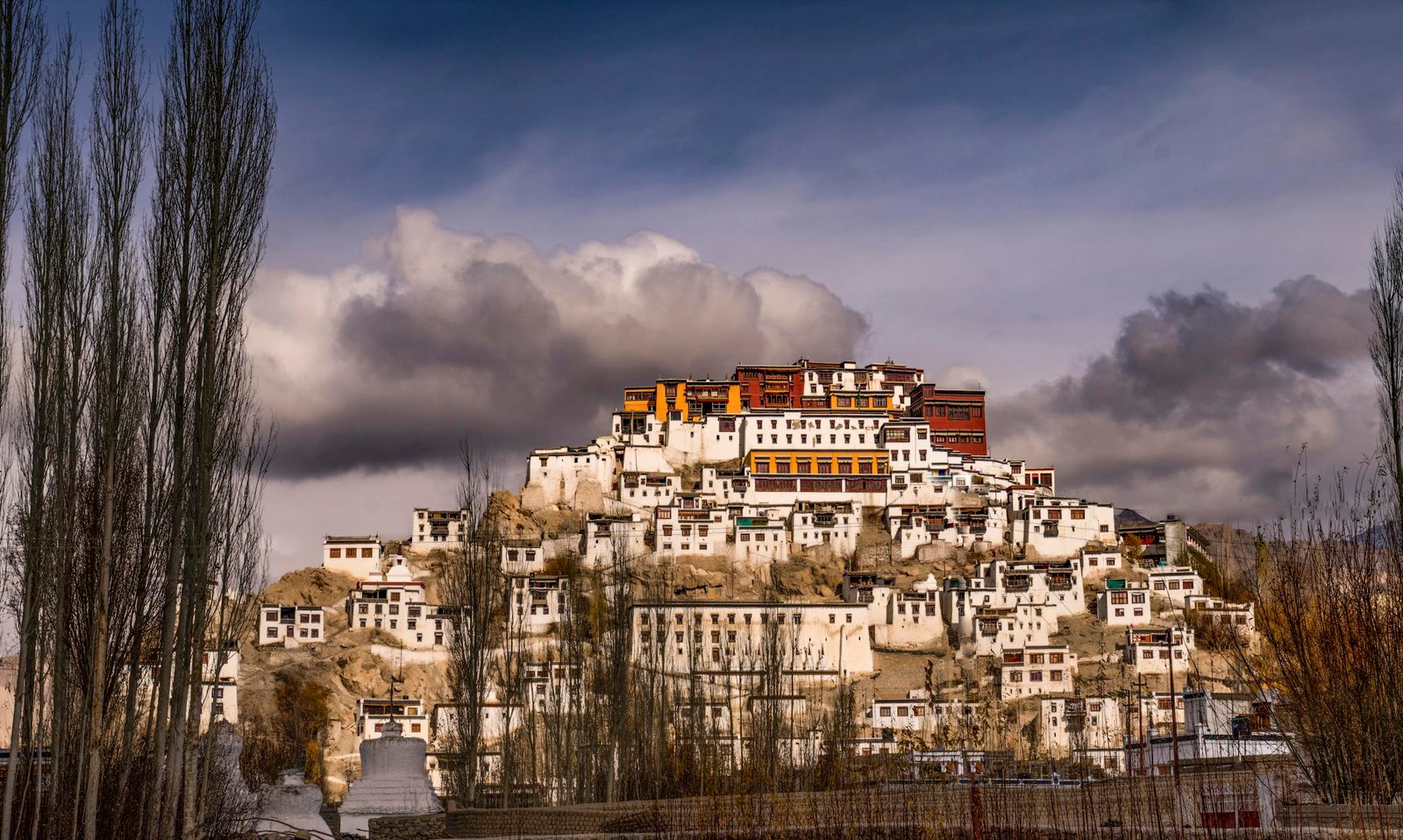 Stunning view of Thiksey Monastery under dramatic clouds in Leh, India.